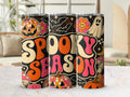 Preview of Spooky Season lettering, disco pumpkins, ghosts, bats, flowers and checkered accents on a tumbler mockup